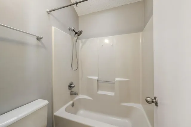 a bathroom with a white bath tub a shower and a toilet sink