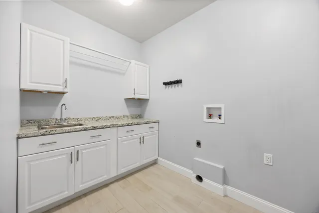 a bathroom with a granite countertop sink and white cabinets