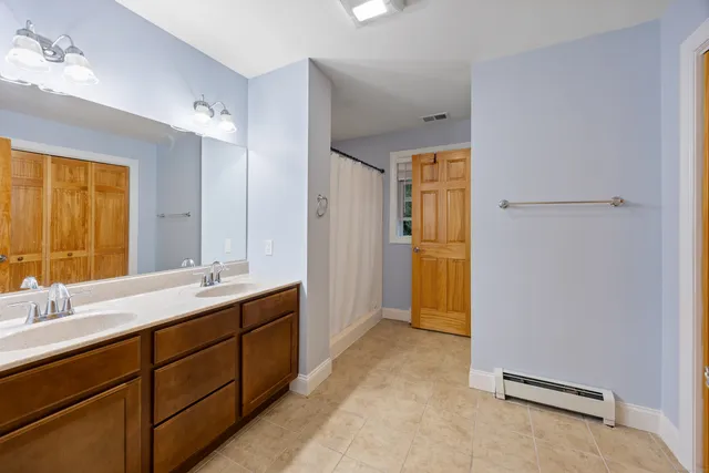 a spacious bathroom with a mirror sink and toilet