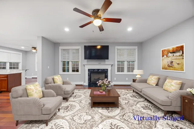a living room with furniture a fireplace and a flat screen tv