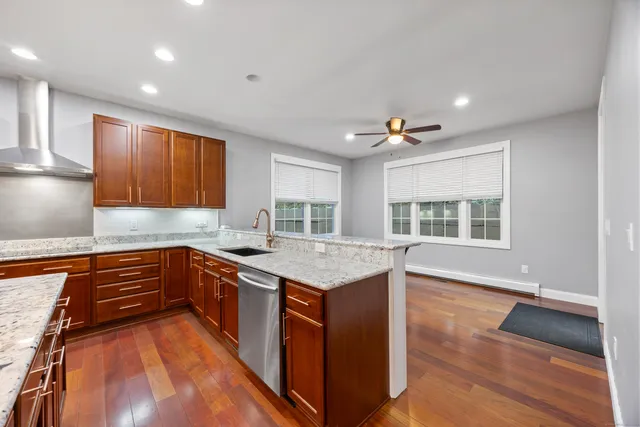 a kitchen with stainless steel appliances granite countertop a sink and wooden cabinets