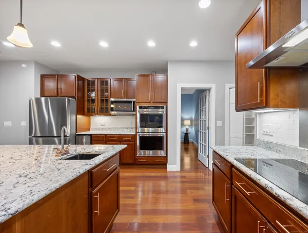 a kitchen with stainless steel appliances granite countertop a sink and cabinets