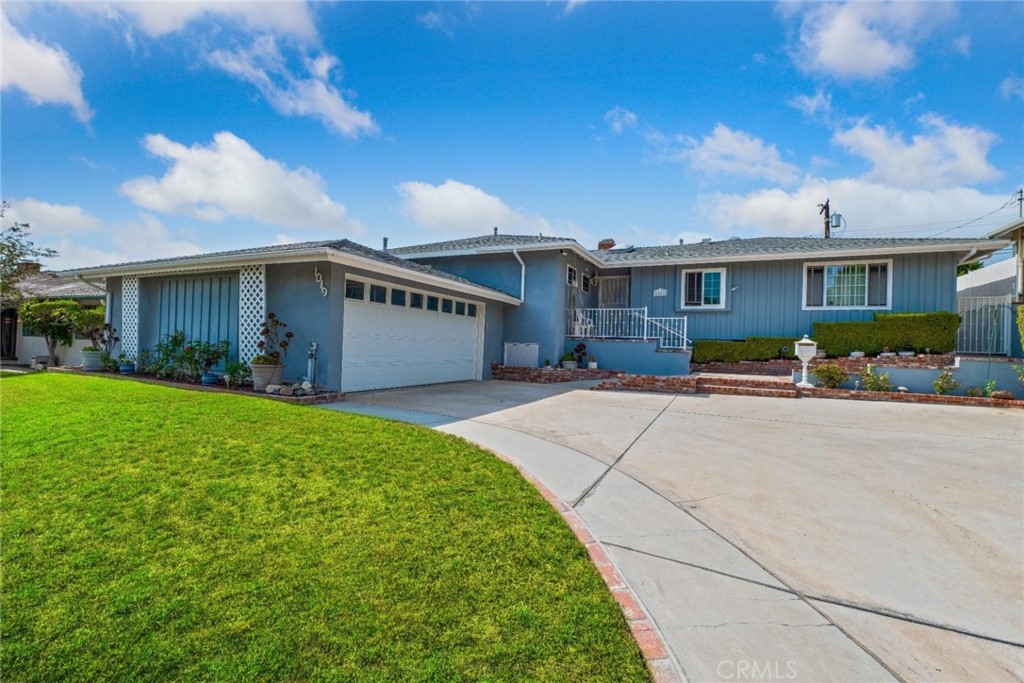 a front view of a house with a yard and potted plants