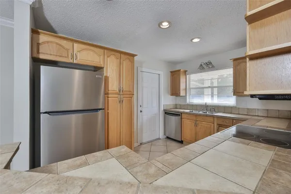 a kitchen with stainless steel appliances granite countertop a refrigerator and a sink