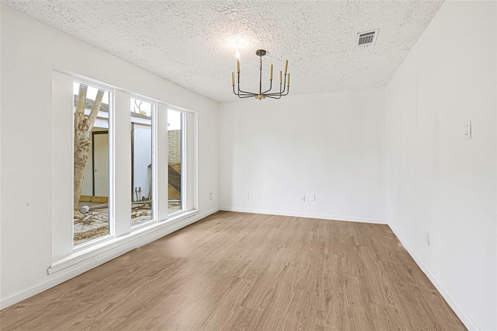 8302 Country Wind Lane Houston, TX 77040 - Photo 4 of 20 wooden floor in an empty room with windows