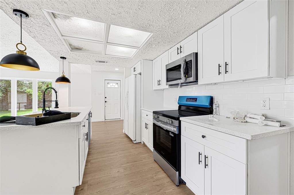 8302 Country Wind Lane Houston, TX 77040 - Photo 9 of 20 a kitchen with stainless steel appliances granite countertop a sink stove and refrigerator