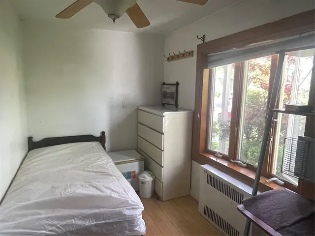a bedroom with a bed and a flat tv screen on the dresser