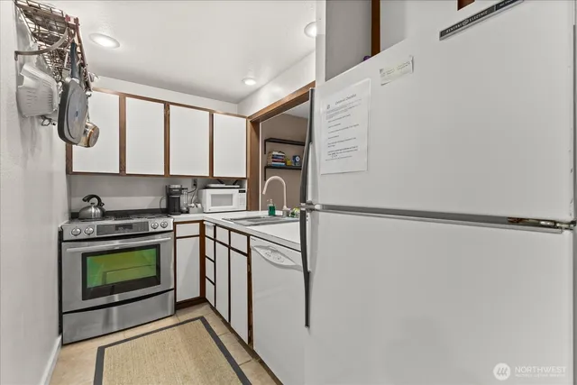 a kitchen with stainless steel appliances granite countertop a stove a sink and a refrigerator