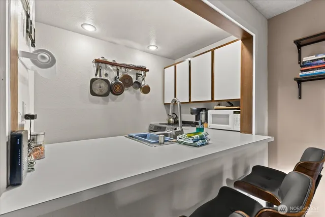 a view of kitchen with kitchen island sink stove and chairs