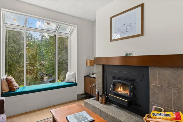 a living room with a fireplace windows and a table