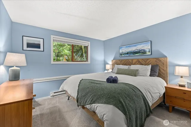 a bedroom with two beds and a lamp on dresser
