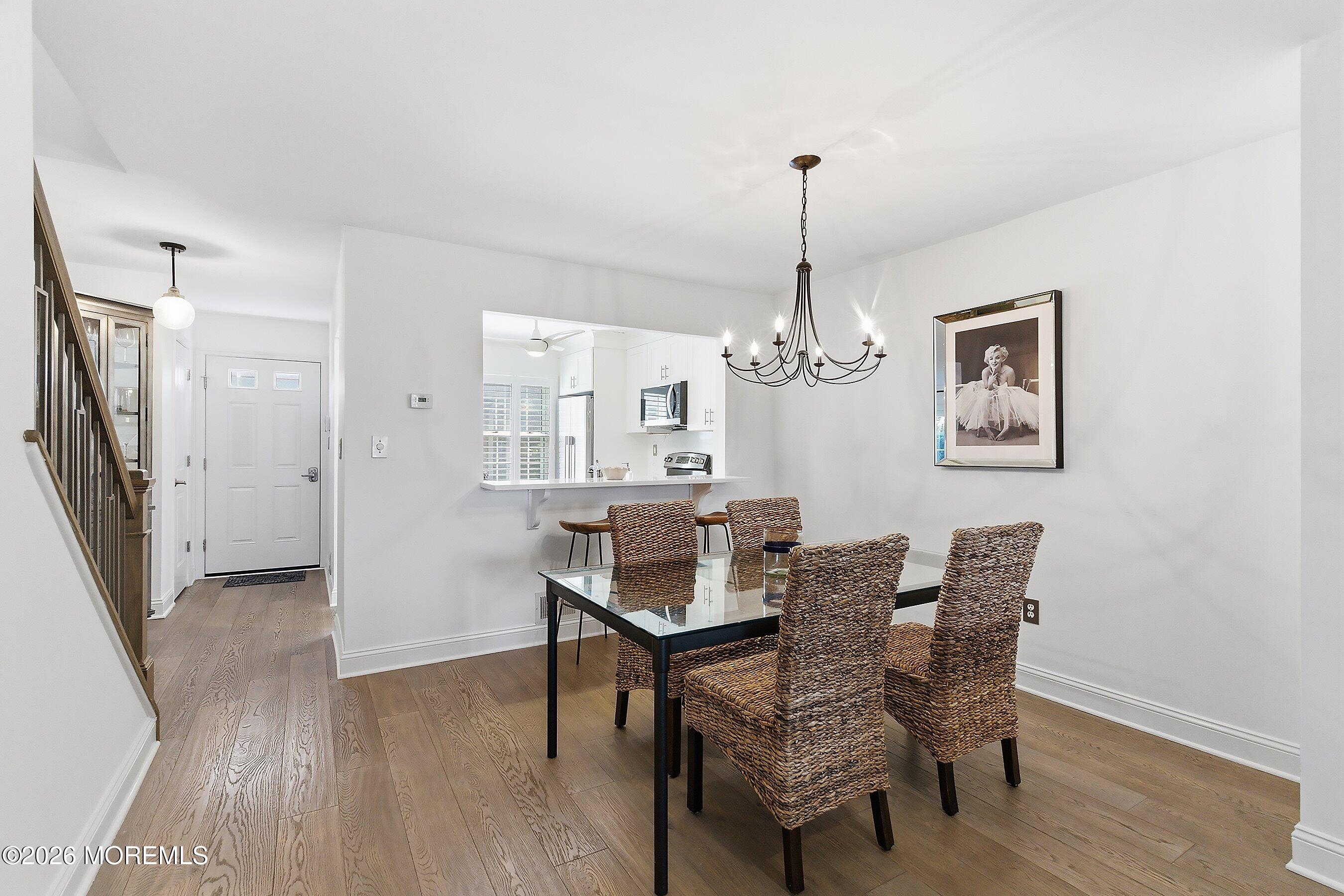 60 Wyckham Road Spring Lake Heights, NJ 07762 - Photo 10 of 26 a dining room with furniture wooden floor a rug and a chandelier