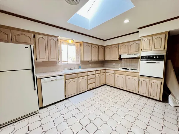 a kitchen with stainless steel appliances granite countertop a refrigerator sink and white cabinets