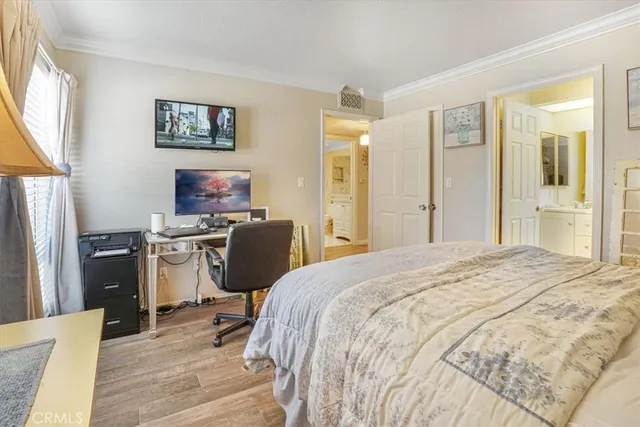 a bedroom with a bed cabinets and a window