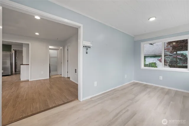 a view of empty room with window and wooden floor