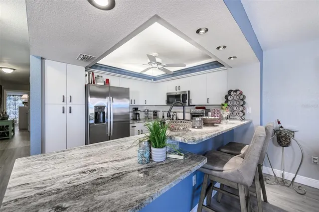 a kitchen with stainless steel appliances granite countertop a sink stove and cabinets