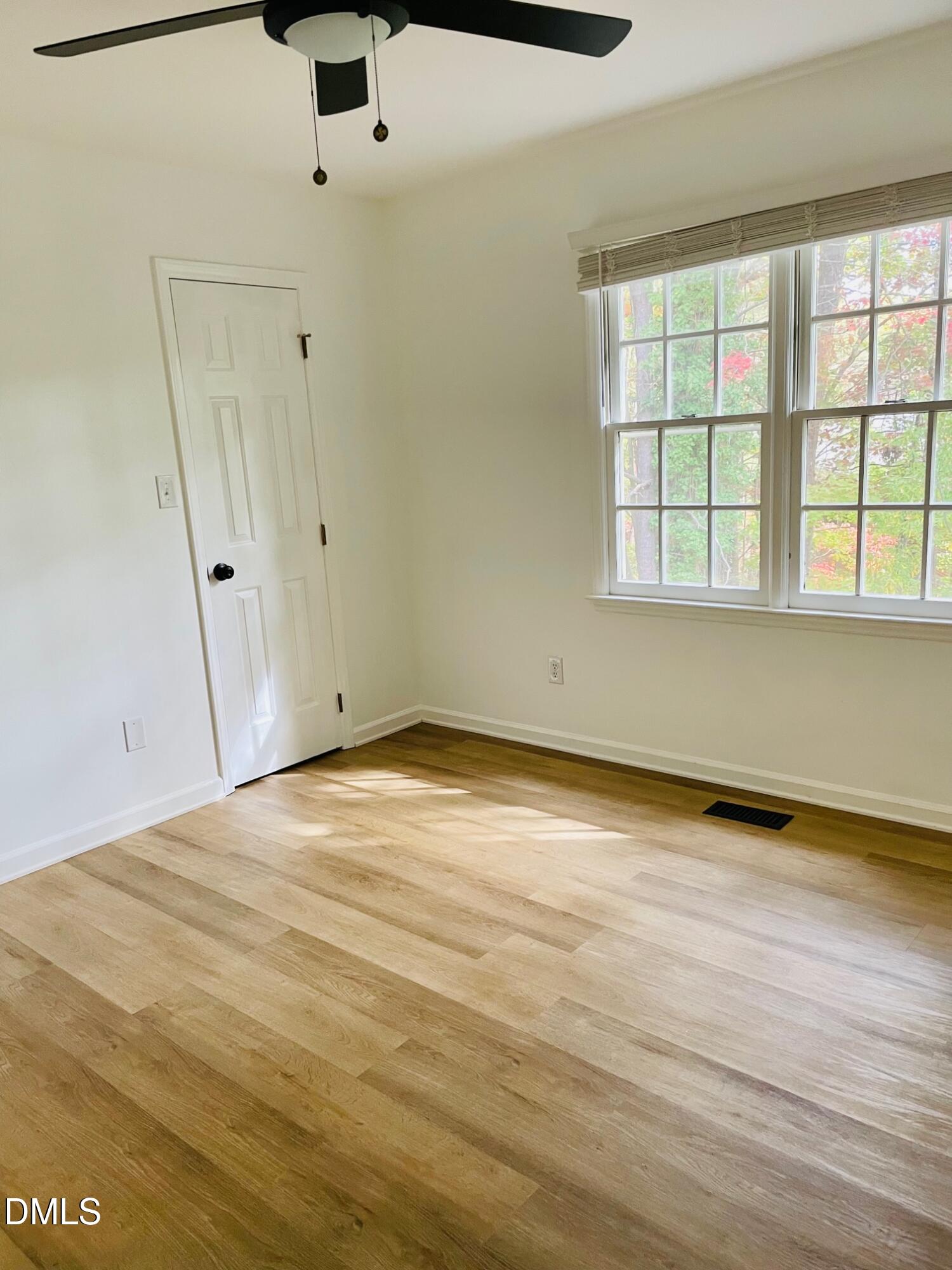 122 Winners Circle Cary, NC 27511 - Photo 11 of 14 an empty room with wooden floor and windows