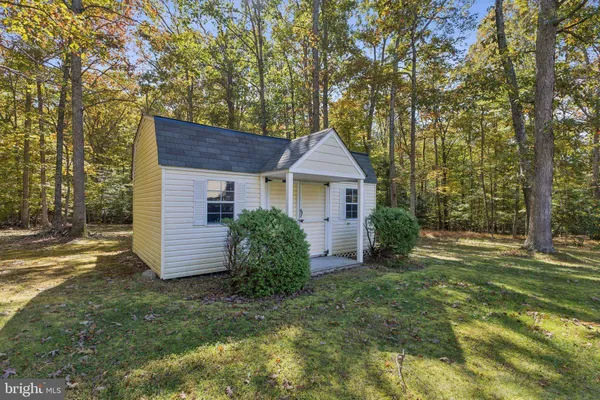 a front view of house with yard and trees in the background