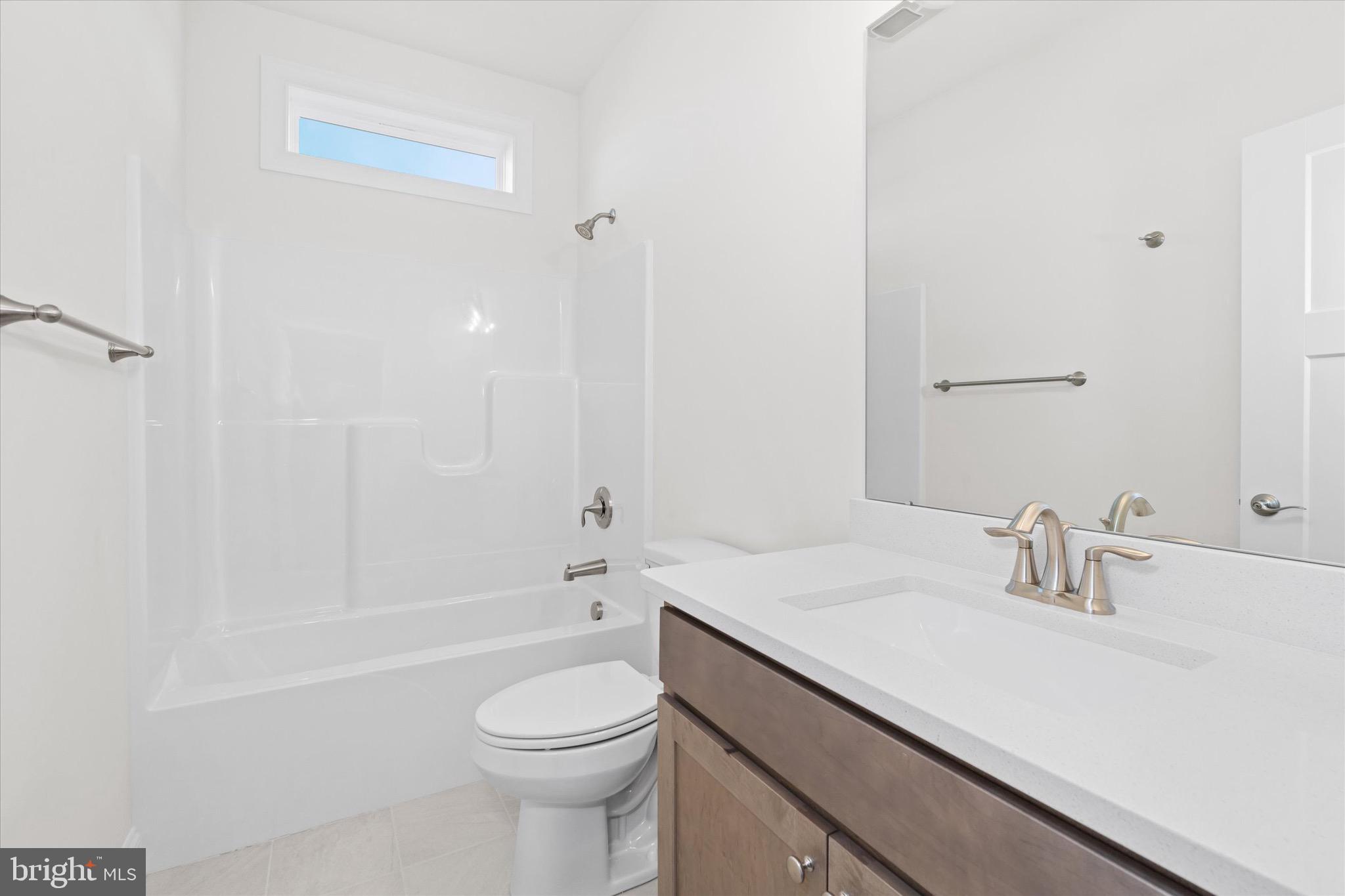22484 Hummingbird Road, Unit 13 Ellendale, DE 19941 - Photo 21 of 34 a bathroom with a sink a toilet and shower