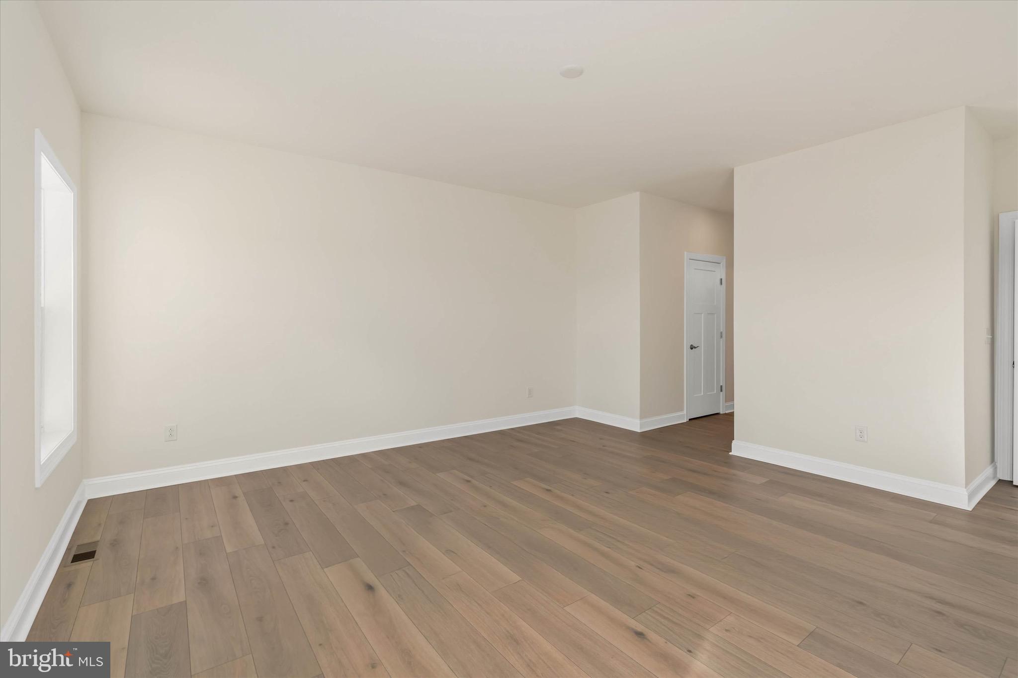 22484 Hummingbird Road, Unit 13 Ellendale, DE 19941 - Photo 28 of 34 an empty room with wooden floor