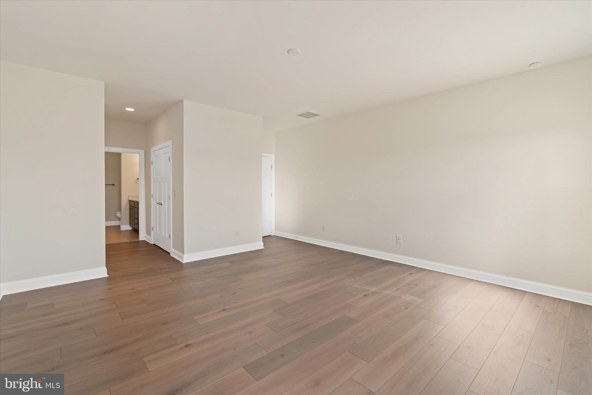 22484 Hummingbird Road, Unit 13 Ellendale, DE 19941 - Photo 29 of 34 a view of an empty room with wooden floor