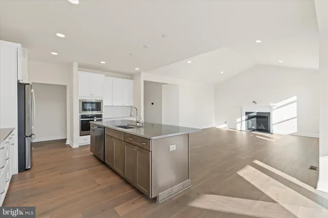 a large kitchen with stainless steel appliances kitchen island granite countertop a large counter top and a stove top oven