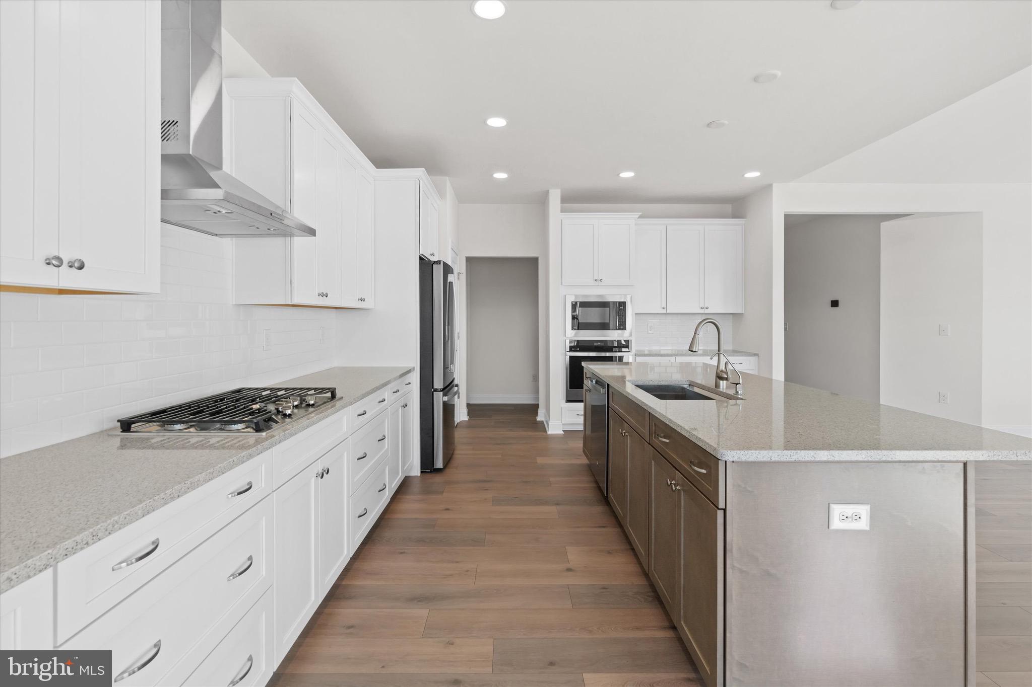 22484 Hummingbird Road, Unit 13 Ellendale, DE 19941 - Photo 4 of 34 a large kitchen with stainless steel appliances granite countertop a stove a sink dishwasher and a refrigerator