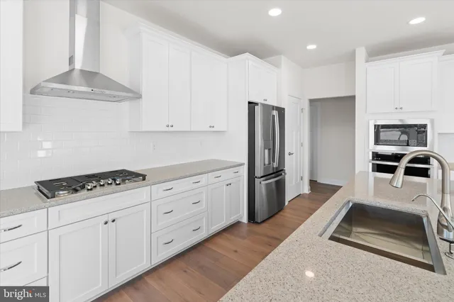 a kitchen with granite countertop a stove a sink and a refrigerator