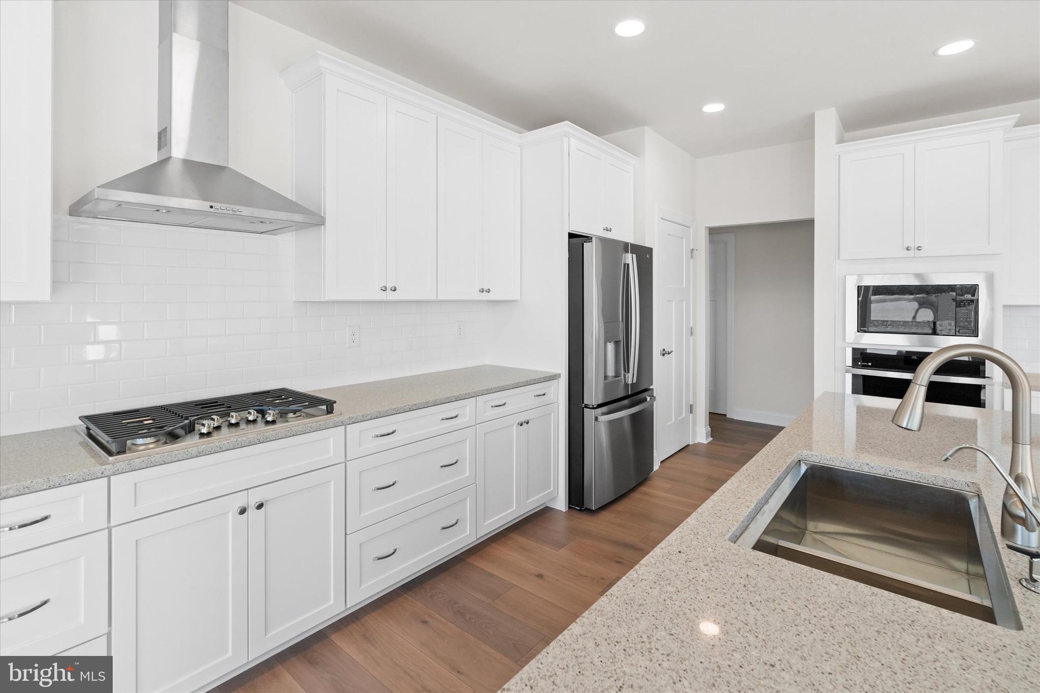 22484 Hummingbird Road, Unit 13 Ellendale, DE 19941 - Photo 5 of 34 a kitchen with granite countertop a stove a sink and a refrigerator
