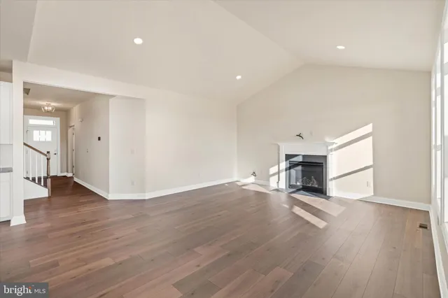 a view of empty room with wooden floor and fireplace