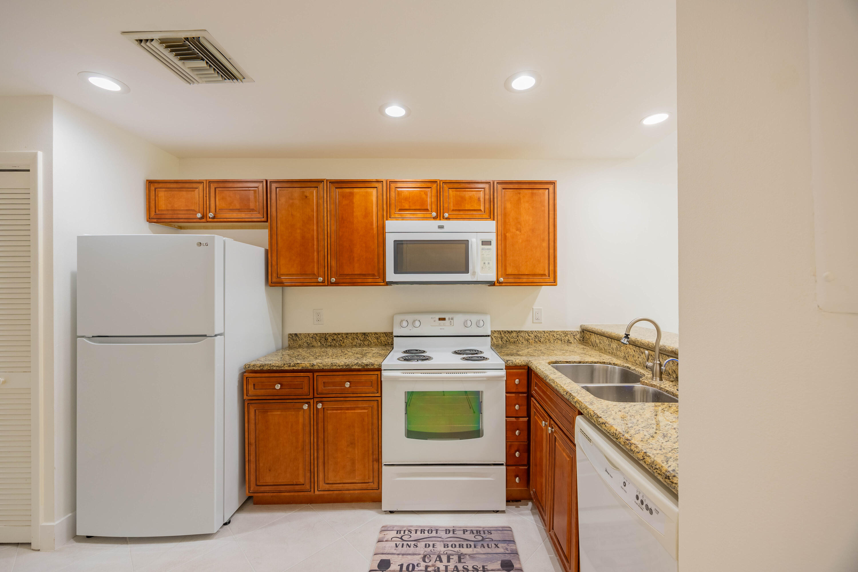 7520 La Paz Boulevard, Unit 104 Boca Raton, FL 33433 - Photo 13 of 56 a kitchen with a sink a stove and a refrigerator