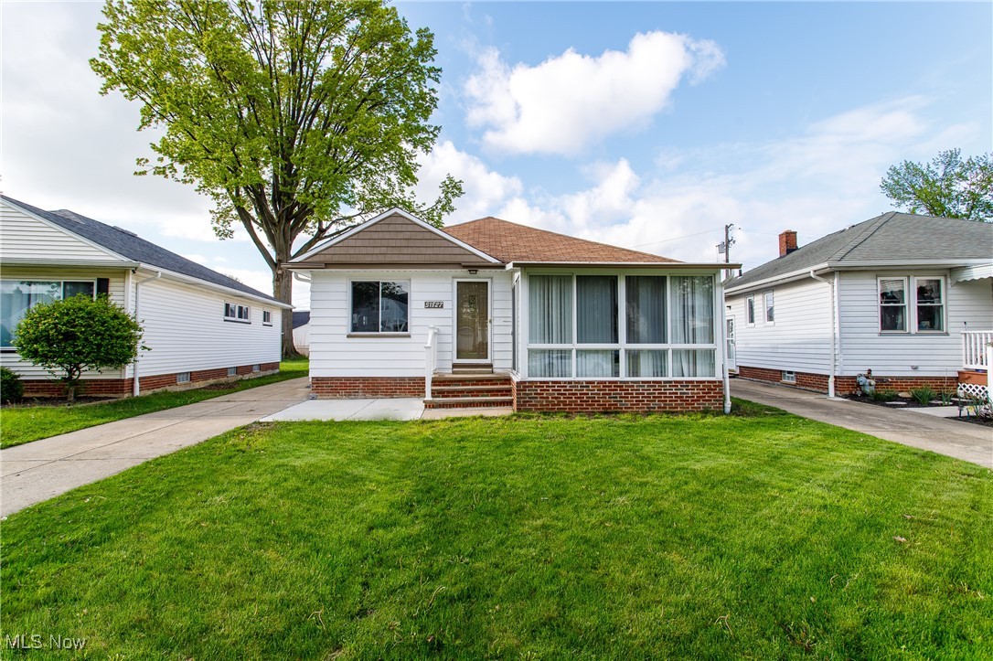 Bungalow featuring entry steps and a front yard