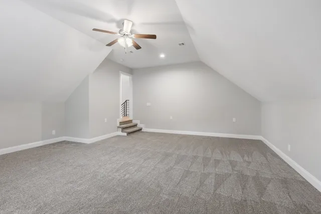 wooden floor in an empty room with a chandelier fan