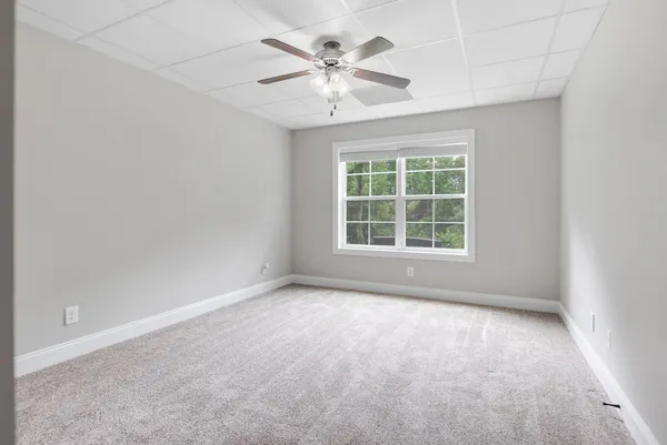 an empty room with window and ceiling fan