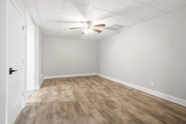 an empty room with ceiling fan and window