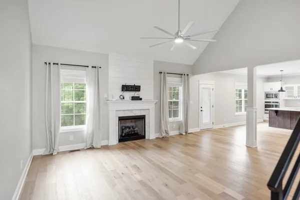 a view of empty room with wooden floor and fireplace