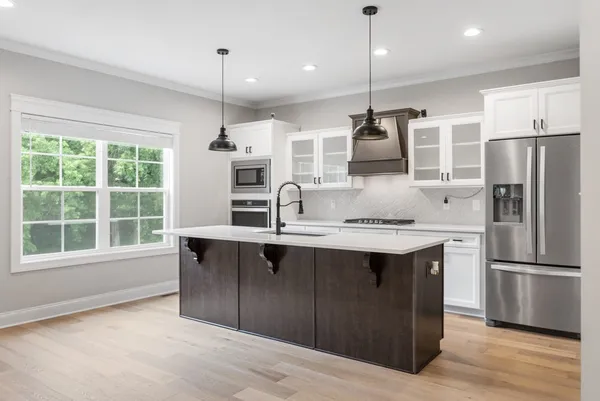 a kitchen with stainless steel appliances granite countertop a sink a stove and a refrigerator