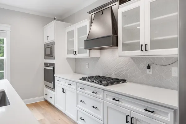 a kitchen with white cabinets and appliances