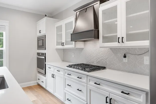 a kitchen with white cabinets and appliances
