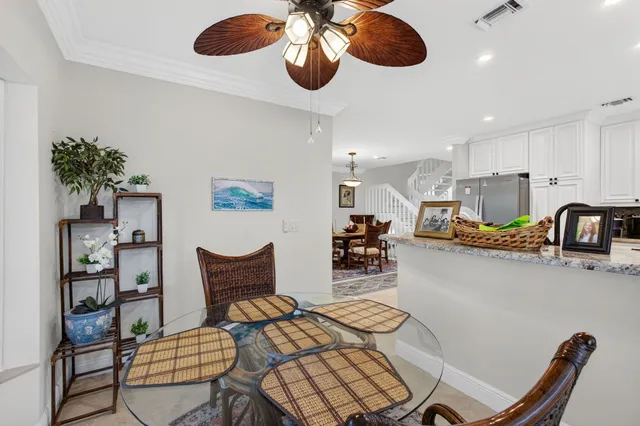 a kitchen with stainless steel appliances granite countertop a stove top oven a sink a dining table and chairs with wooden floor