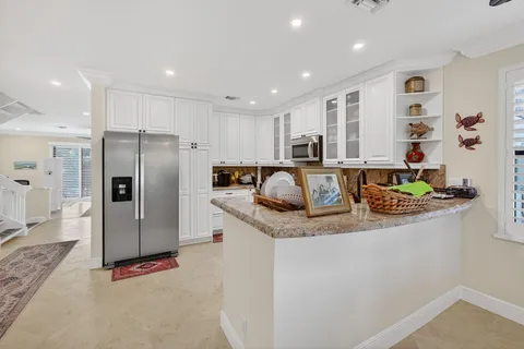 a kitchen with stainless steel appliances granite countertop a refrigerator and a sink