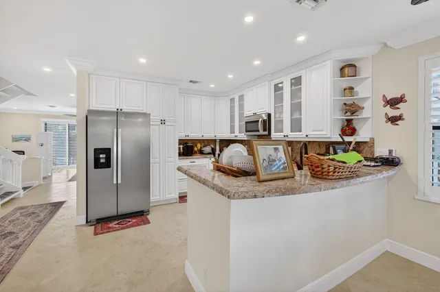 a kitchen with stainless steel appliances granite countertop a refrigerator and a sink