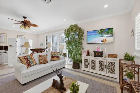 a living room with furniture kitchen view and a chandelier