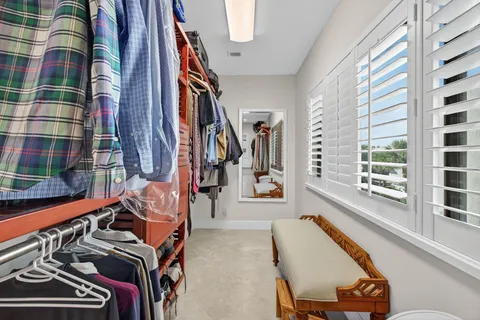 a view of walk in closet with clothes and shoes