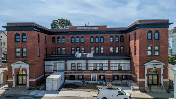 a balcony view with couple of cars parked in front of it