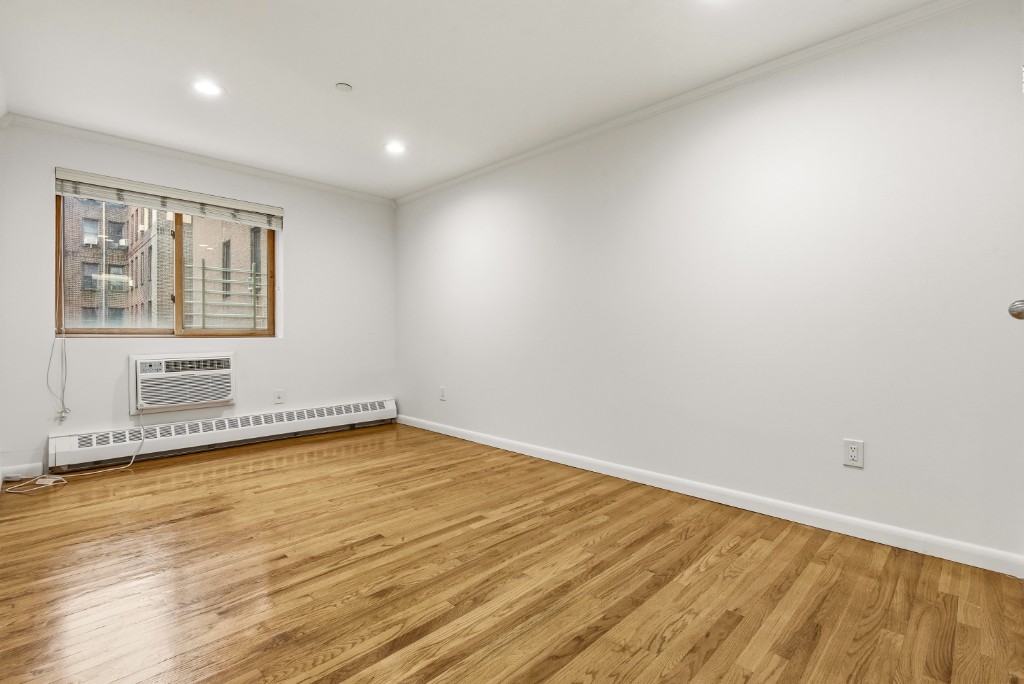 118-82 Metropolitan Avenue, Unit 3A Queens, NY 11415 - Photo 11 of 19 a view of a room with wooden floor and window
