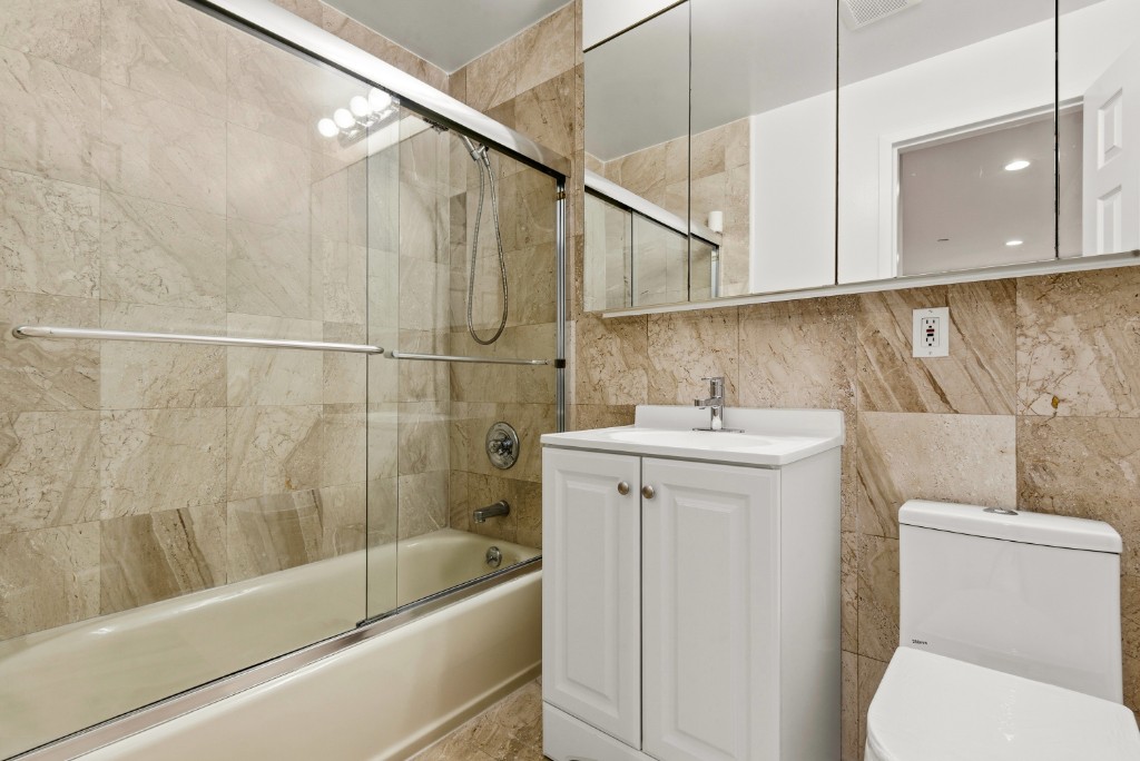 118-82 Metropolitan Avenue, Unit 3A Queens, NY 11415 - Photo 14 of 19 a bathroom with a sink a toilet and shower