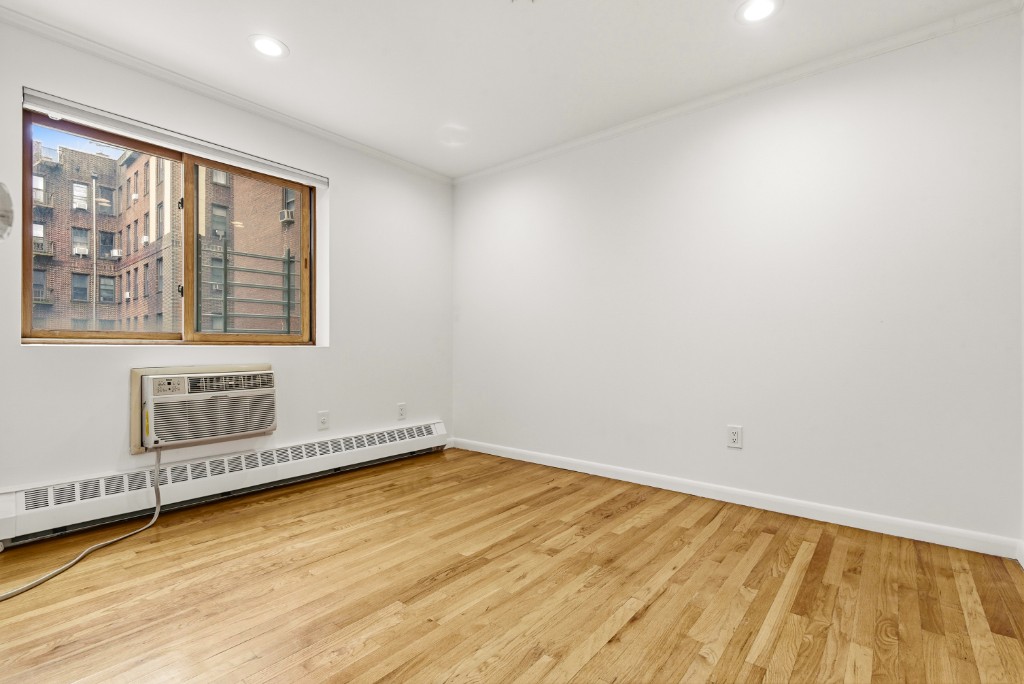 118-82 Metropolitan Avenue, Unit 3A Queens, NY 11415 - Photo 15 of 19 a view of an empty room with a window and wooden floor