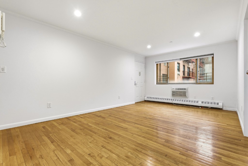 118-82 Metropolitan Avenue, Unit 3A Queens, NY 11415 - Photo 4 of 19 a view of empty room with wooden floor and fan