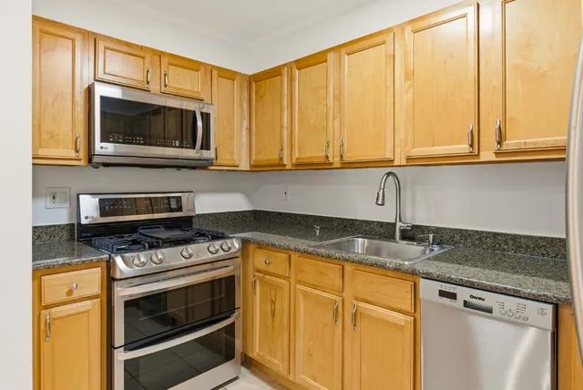 a kitchen with stainless steel appliances granite countertop a refrigerator and a sink